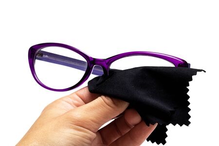 Wipes glasses with a black napkin isolated on white background