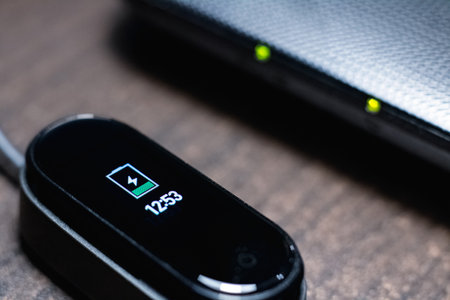 BELARUS, MINSK - OCTOBER 31, 2019: Xiaomi Mi Band 4 is charging from a laptop close upのeditorial素材