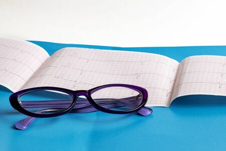 Glasses on a cardiogram chart close upの写真素材