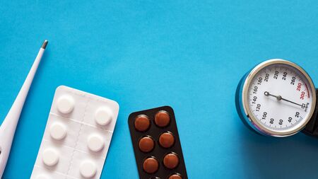 Thermometer, tonometer and pills, medical themed background