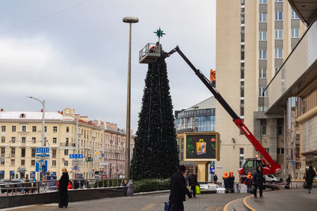 BELARUS, MINSK - DECEMBER 03, 2019: Workers install big New Year tree on the streetのeditorial素材