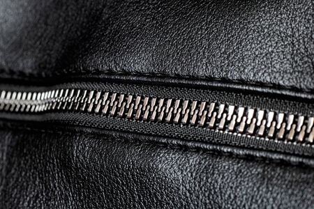 Metal clasp and zipper on leather close upの写真素材