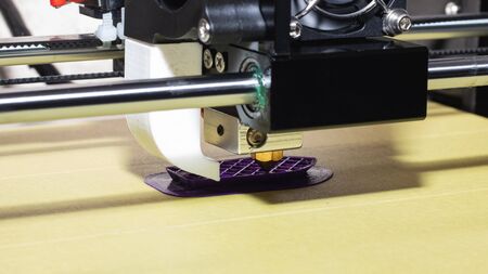 The process of printing from plastic to a 3D printer close up