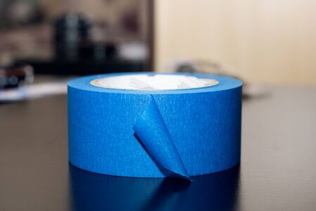 Blue masking tape on a black wooden table close upの写真素材