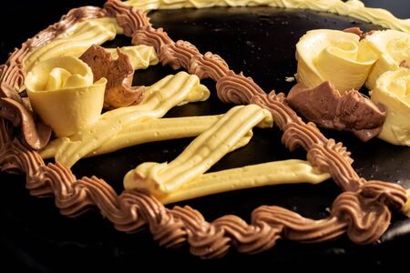 Chocolate cake with yellow cream close up, top viewの写真素材