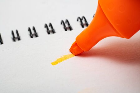 Orange marker and line on notepad paper close upの写真素材