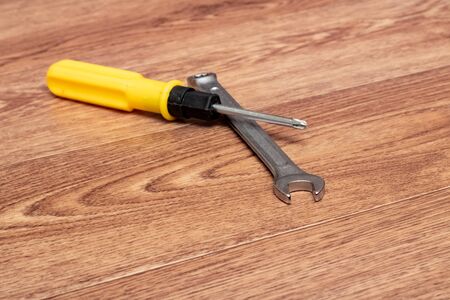 Screwdriver and wrench on a wooden table close upの写真素材