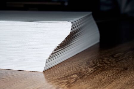 Stack of white paper on a wooden table