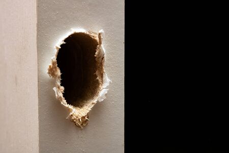 Drilled hole in a white wooden door close upの写真素材