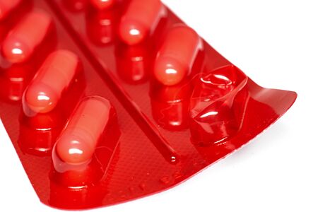 Red packaging with pills on a white background close up