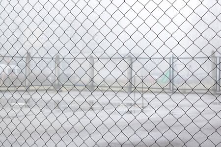 Fence net against the backdrop of a playground for games in the fogの写真素材