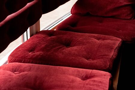 Red velvet pillows on a bench close upの写真素材