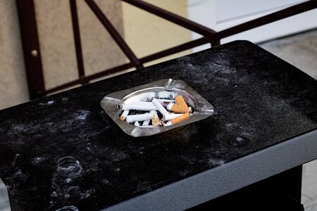 Cigarette butts in the smoking area close upの写真素材