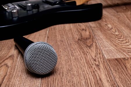 Microphone and guitar on a wooden background, copy space