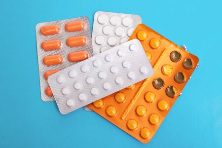 Pile of packs of pills on blue background close upの写真素材