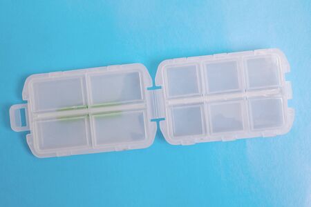 Plastic container for pills on a blue background