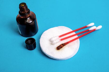 Jar with medical iodine and cotton buds on a blue background, top viewの写真素材