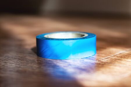 Coil of electrical tape on a wooden table close upの写真素材