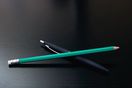 Pen and pencil on a black wooden table, copy spaceの写真素材