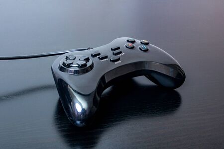 Playing joystick on a black wooden tableの写真素材
