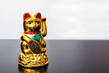 Japanese cat symbol with coins close up on table, copy spaceの写真素材