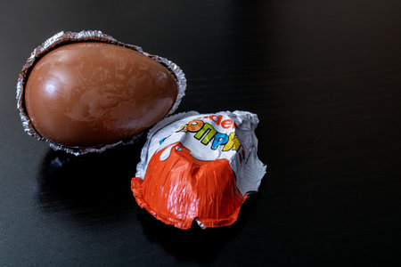 BELARUS, MINSK - JUNE 22, 2020: Kinder surprise chocolate egg on a black backgroundのeditorial素材