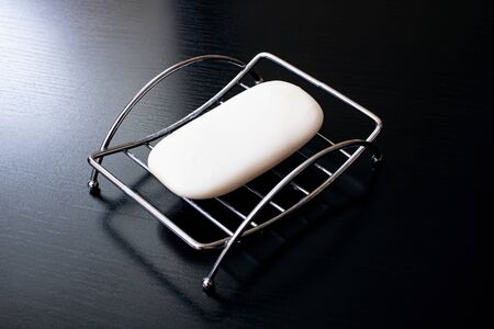 Soap in a metal soapbox on a wooden tableの写真素材