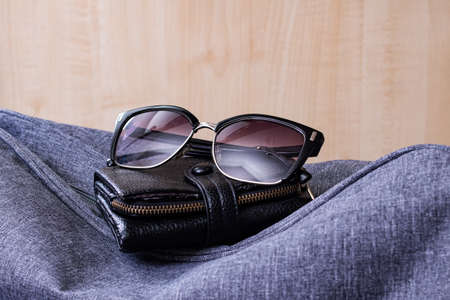 Wallet, sunglasses and travel bag on a wooden backgroundの写真素材