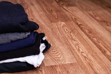 Stack of clothes on a wooden background, copy space