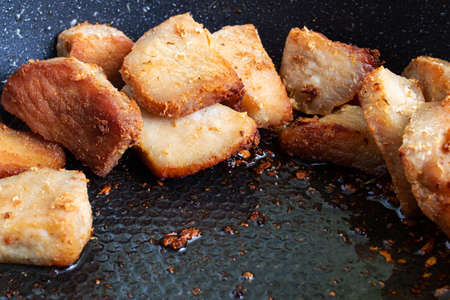 Stir-fried pieces of meat in a pan close upの写真素材