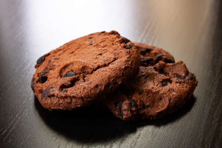 Two cookies with chocolate on a wooden table