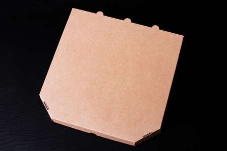 Pizza box on a wooden table copy space