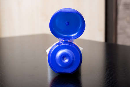 Blue open tube of cream on wooden table close up