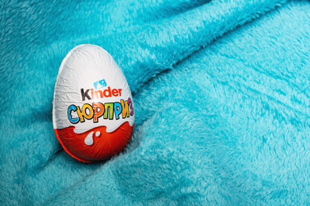 BELARUS, NOVOPOLOTSK - SEPTEMBER 29, 2020: Chocolate egg kinder surprise on blue cloth, copy spaceのeditorial素材