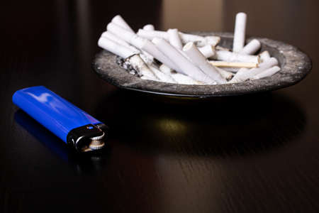 Lighter and ashtray on a wooden table close upの写真素材