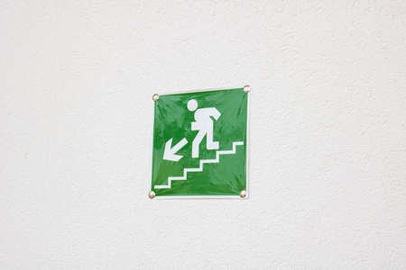 Green sign pointer stairs on the wall close up
