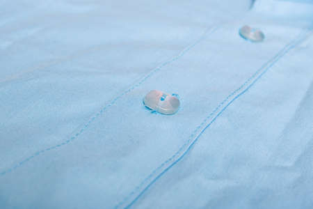 Buttons on a blue shirt close up, macro photo