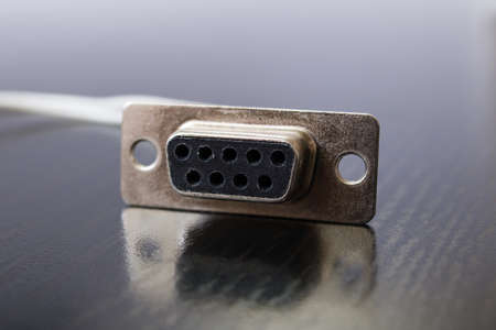 Computer monitor plug on wooden table close up