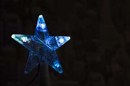 Festive star on the Christmas tree in dark