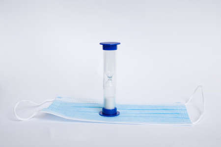 Medical hourglass and medical mask on a white backgroundの写真素材