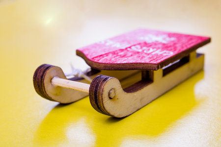 Decorative wooden sleigh on a yellow background close upの写真素材