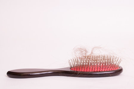Comb and hair on white background close up, alopecia