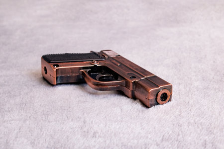 Metal fake pistol on gray background close upの写真素材