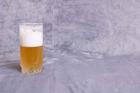 Beer with foam in a transparent glass close upの写真素材