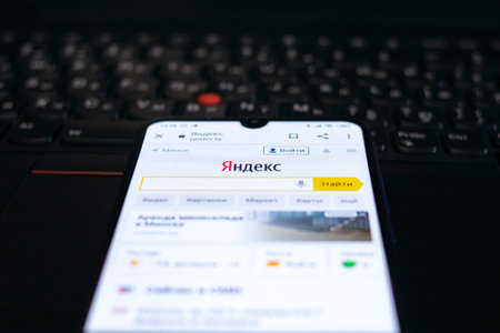 NOVOPOLOTSK, BELARUS - 06 FEBRUARY, 2021: Phone in hand and yandex logo on a display close up