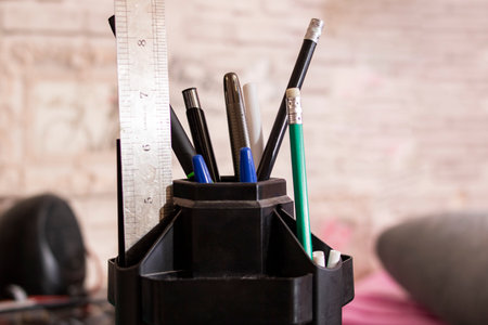 Pencils and pens in a stand on the tableの写真素材