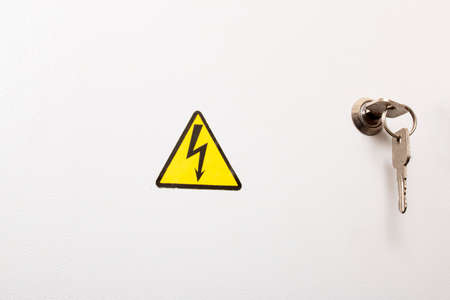 Electricity sign on a metal door with a keyの写真素材