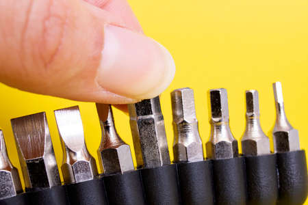 Screwdriver bits in a row on yellow background close upの写真素材