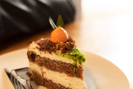 Piece of carrot cake on a plate on a wooden table