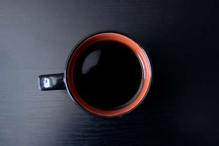 Cup with coffee on a black wooden table top viewの写真素材